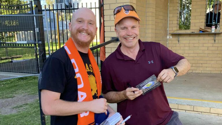 Chris McCoy (left) getting another Roar fan to sign a postcard to the Premier last weekend. (Image supplied by Fair Funding for Football)